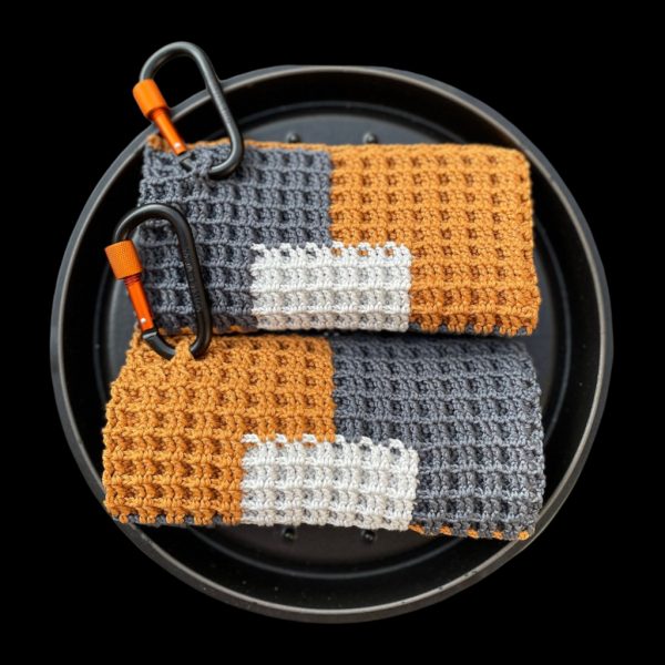 Handgemachte gehäkelte Topflappen online bestellen im Patchwork-Design in Grau, Weiß und Rostbraun, dekorativ zwischen frischem Gemüse arrangiert